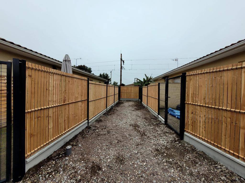 Installation d'une clôture en panneaux rigides avec kit occultant bois pour séparer des logements Macau