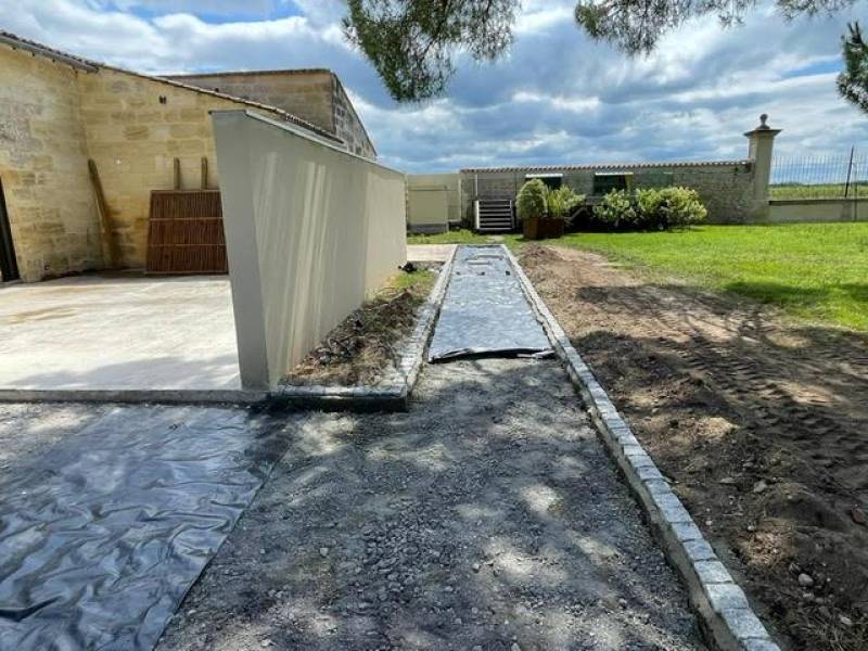 Installation d’un portail coulissant inox et bois avec pose de claustras au Château Dauzac à Labarde 33460 avec mise en œuvre d’un béton désactivé extérieur – Réalisation signée AQUITAINE CLÔTURE