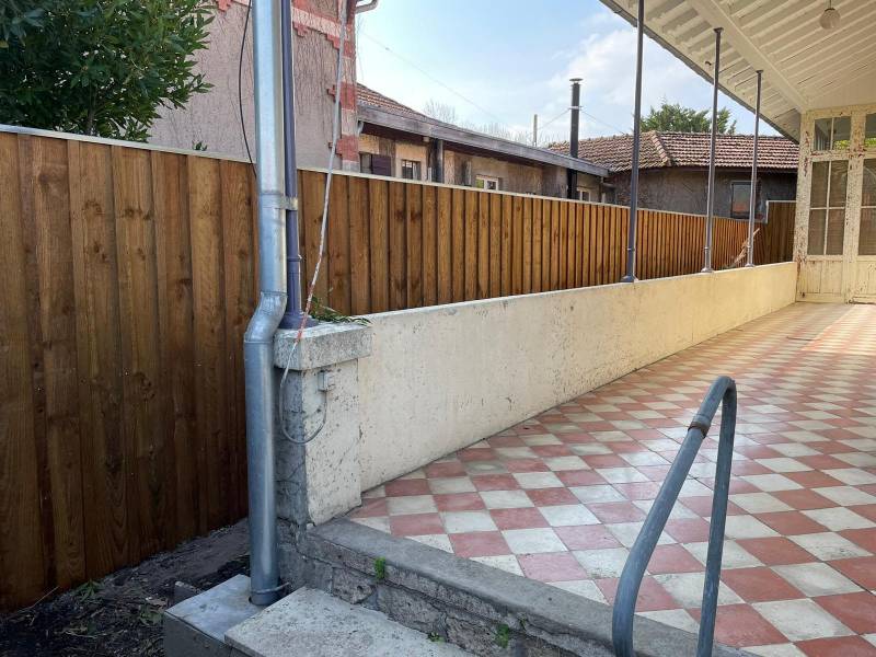 Installateur de clôture en bois volige sur-mesure avec couvertines en alu vers Arès 33