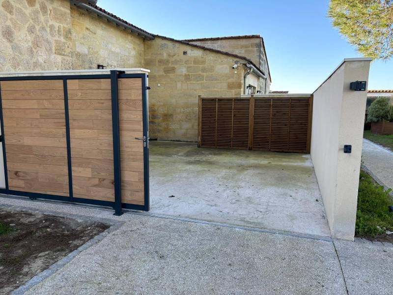 Installation d’un portail coulissant inox et bois avec pose de claustras au Château Dauzac à Labarde 33460 avec mise en œuvre d’un béton désactivé extérieur – Réalisation signée AQUITAINE CLÔTURE